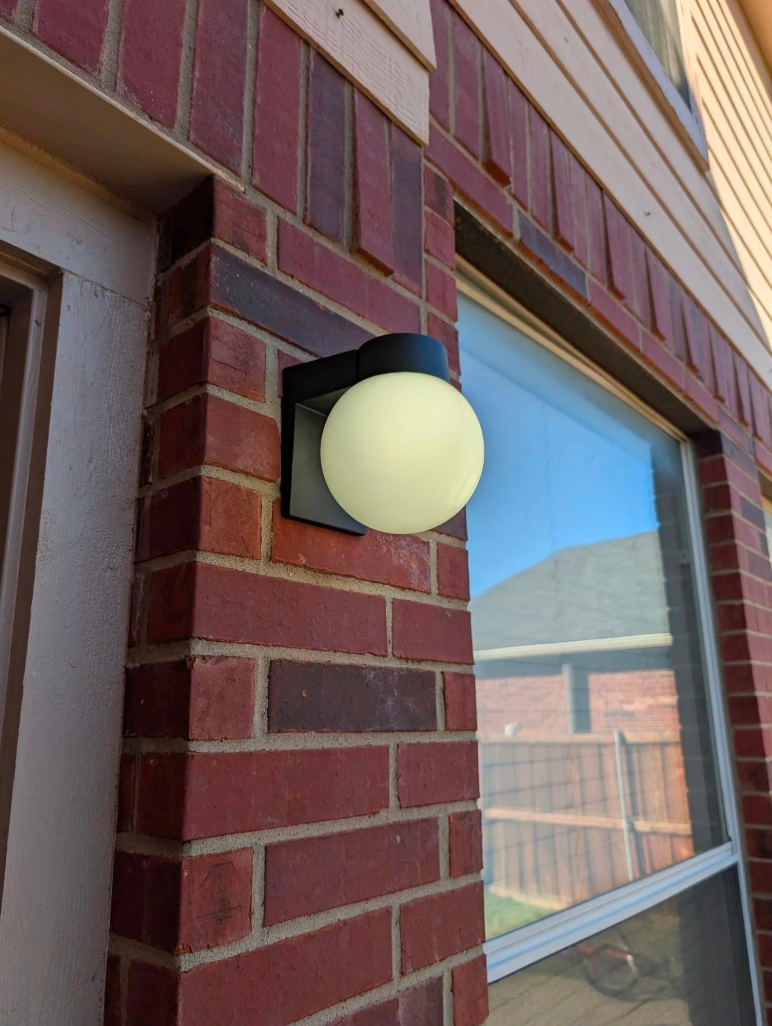 Modern globe light fixture installed on brick
