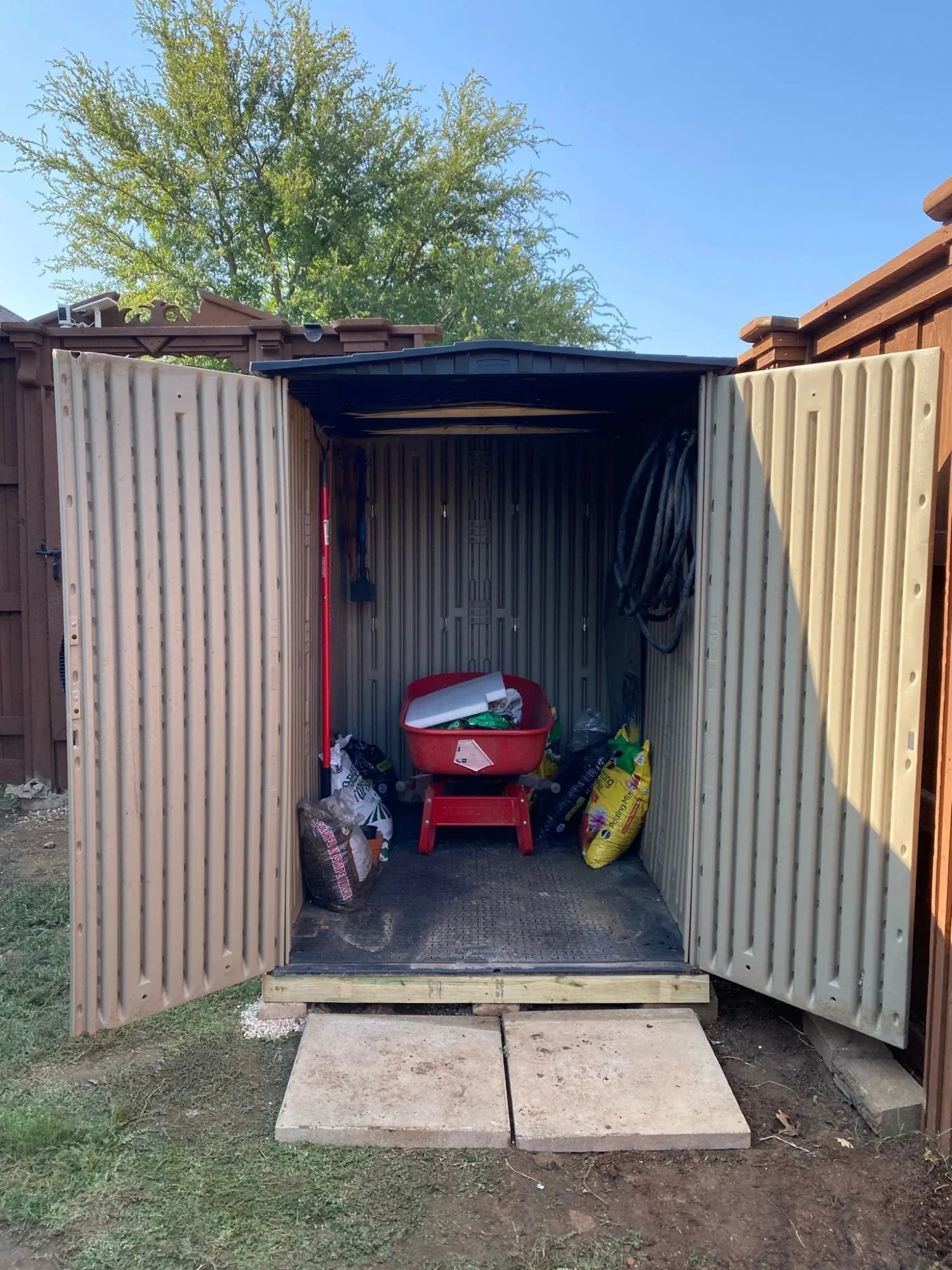 Storage shed with doors open showing organized interior